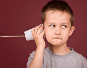 communications protocol website tile: young boy with string and cup phone held to his ear