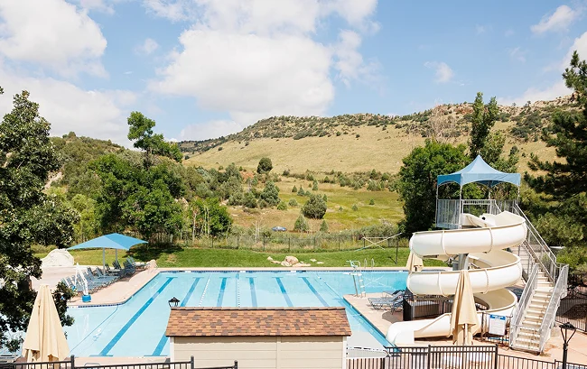 Outdoor swimming pool with lap lanes and a large white waterslide.